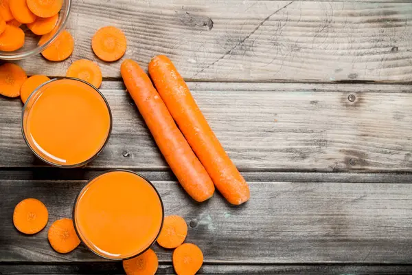 Bir bardak havuç suyu. Ahşap arka plan üzerinde