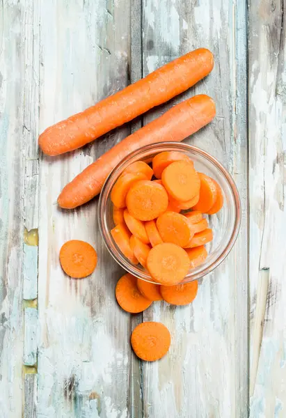 Bir cam kapta havuç parçalarını. Ahşap arka plan üzerinde