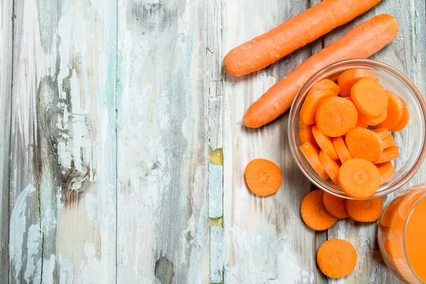 Bir cam kapta havuç parçalarını. Ahşap arka plan üzerinde