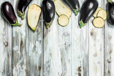 Bütün patlıcan ve patlıcan dilim. Beyaz ahşap arka plan üzerinde