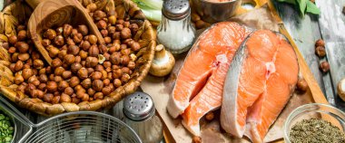 Sağlıklı gıda. Organik sebze, meyve ve fındık ile somon. Rustik bir arka plan üzerinde.