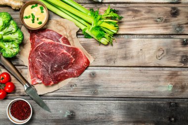 Sağlıklı gıda. Ham sığır çeşitli organik gıda ve baharatlar ile. Ahşap bir arka plan üzerinde.