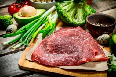 Sağlıklı gıda. Organik gıda ham sığır eti ile çeşitli. Ahşap bir arka plan üzerinde.