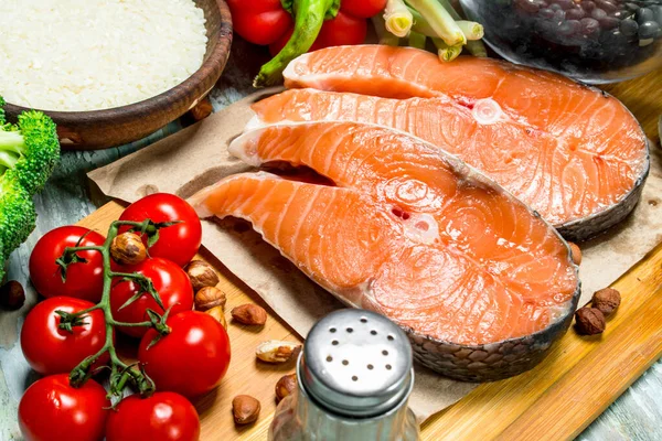 stock image Healthy food. Salmon steaks with organic food. On a rustic background.