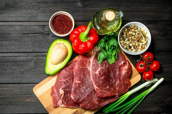 stock image Healthy food. Raw beef meat with organic food assortment .On a wooden background.