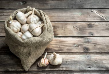 Taze sarımsak yatakta. Ahşap arka plan üzerinde