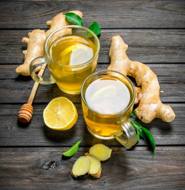 Zencefil çayı ve limon yaprakları ile. Siyah ahşap arka plan üzerine