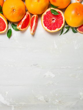 Yaprakları ile sulu greyfurt. Beyaz rustik arka plan üzerinde