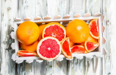 Olgun greyfurt kutusunda. Ahşap arka plan üzerinde