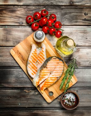 Domates ve baharat ile ızgara somon. Ahşap bir arka plan üzerinde.