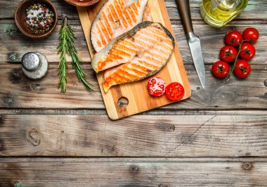 Domates ve baharat ile ızgara somon. Ahşap bir arka plan üzerinde.