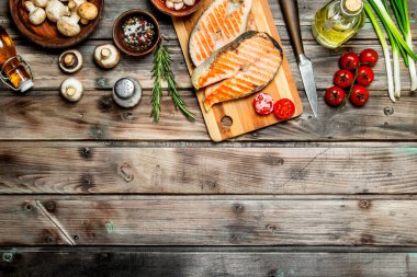 Domates ve baharat ile ızgara somon. Ahşap bir arka plan üzerinde.