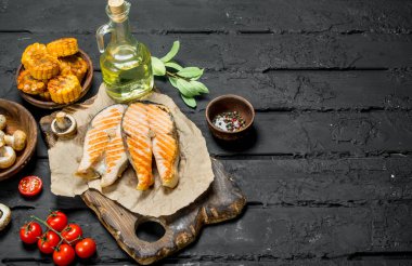 Somon ızgara biftek sebze ve baharatlar ile. Rustik siyah arka plan üzerine.