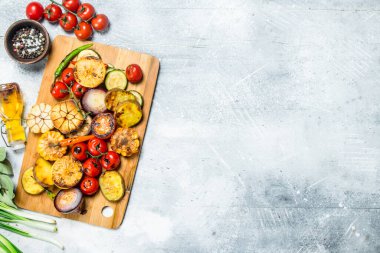 Baharatlar ve otlar bir kesme tahtası üzerinde ızgara sebze. Rustik bir arka plan üzerinde.