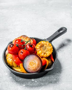 Baharat ile bir tavada ızgara sebze. Rustik bir arka plan üzerinde.