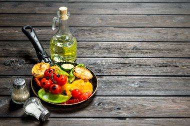 Bir tava ile ızgara sebze çeşitli. Ahşap bir arka plan üzerinde.