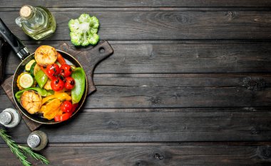 Bir tava ile ızgara sebze çeşitli. Ahşap bir arka plan üzerinde.