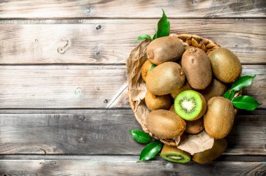 Taze kivi sepet yaprakları ile. Ahşap arka plan üzerinde