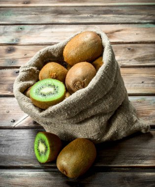 Bir çuval içinde taze kivi. Ahşap arka plan üzerinde