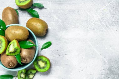 Kivi yaprakları bir kase ile. Rustik arka plan üzerinde