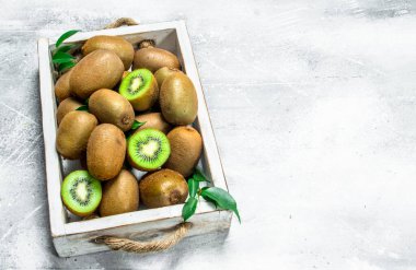 Sulu kivi içinde ahşap tepsi. Beyaz rustik arka plan üzerinde