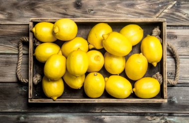 Taze limon içinde belgili tanımlık tepsi. Ahşap arka plan üzerinde