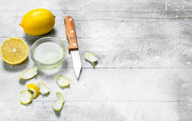 Bir bıçak ve bir limon lezzet ile limon suyu kase. Rustik arka plan üzerinde