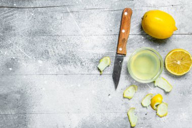 Bir bıçak ve bir limon lezzet ile limon suyu kase. Rustik arka plan üzerinde