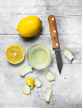 Bir bıçak ve bir limon lezzet ile limon suyu kase. Rustik arka plan üzerinde