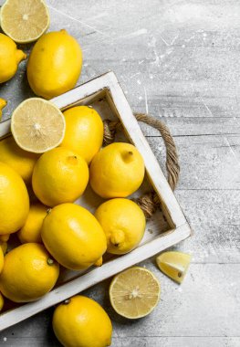 Taze limon içinde belgili tanımlık tepsi. Beyaz bir rustik arka plan üzerinde