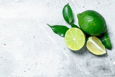 Bütün ve yaprakları ile taze limon parçaları. Rustik arka plan üzerinde