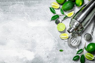 Shaker adet Sulu kireç ve yaprakları ile. Rustik arka plan üzerinde