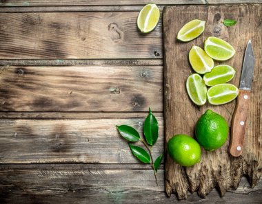 Bir bıçak ile kesme tahtası üzerinde taze limon parçaları. Ahşap arka plan üzerinde