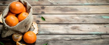 Taze mandalina yatakta. Ahşap arka plan üzerinde