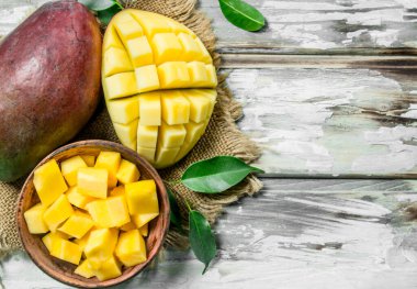 Mango dilimleri peçete üzerinde bir kasede. Beyaz ahşap arka plan üzerinde