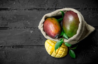 Yatakta olgun mango. Rustik siyah arka plan üzerine