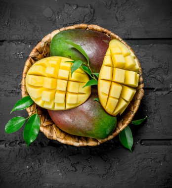 Sepet içinde aromatik taze mango. Rustik arka plan üzerinde