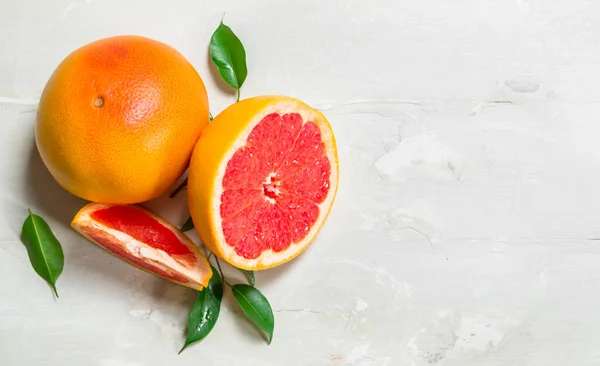 stock image Juicy grapefruit with leaves. On white rustic background