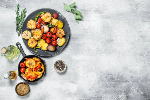 Various grilled vegetables with spices and herbs. On a rustic background.