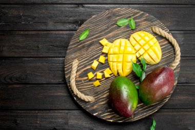 Mango bir tepsi üzerinde kesti. Siyah ahşap arka plan üzerine