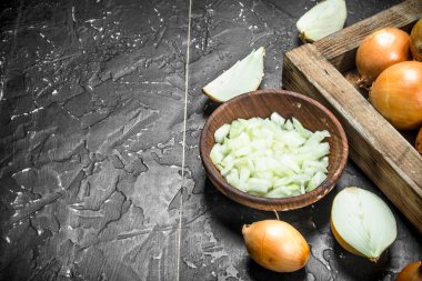 Kasede soğan parçaları ve tepside bir bütün soğan. Rustik arka planda