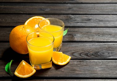 Portakal suyu bir bardak taze portakal. Ahşap arka plan üzerinde