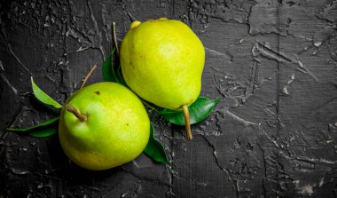 Yeşillik ile taze olgun armut. Rustik arka plan üzerinde