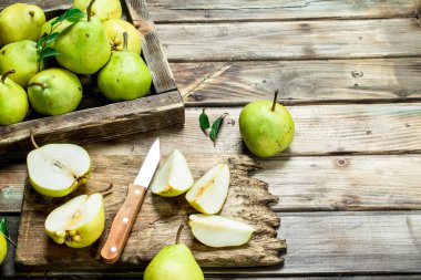 Taze armut tepsi ve tahta bıçak ile kesme üzerinde dilimlenmiş armut. Ahşap arka plan üzerinde