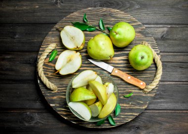 Bir bıçakla tepsisindeki armut dilimleri. Siyah ahşap arka plan üzerine