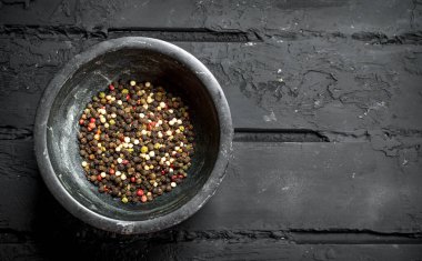 Bir kasede biber. Siyah rustik arka plan üzerinde