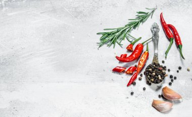 Kırmızı biber, biberiye ve sarımsak parçaları ile bir kaşık biber bezelye. Rustik arka planda