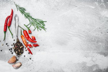 Kırmızı biber, biberiye ve sarımsak parçaları ile bir kaşık biber bezelye. Rustik arka planda