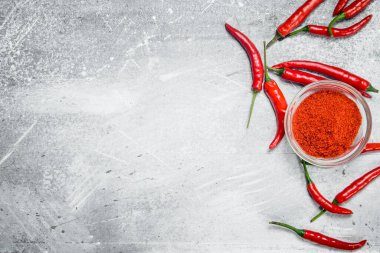 Bir cam kase ve taze kırmızı biber biberiye ile kara biber. Rustik arka plan üzerinde