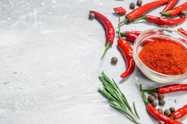 Bir cam kase ve taze kırmızı biber biberiye ile kara biber. Rustik arka plan üzerinde